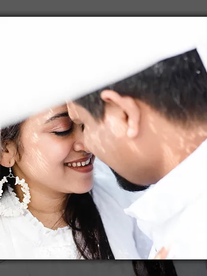 A creative close-up shot, using a white prop to frame the couple's faces for an intimate and artistic portrait.