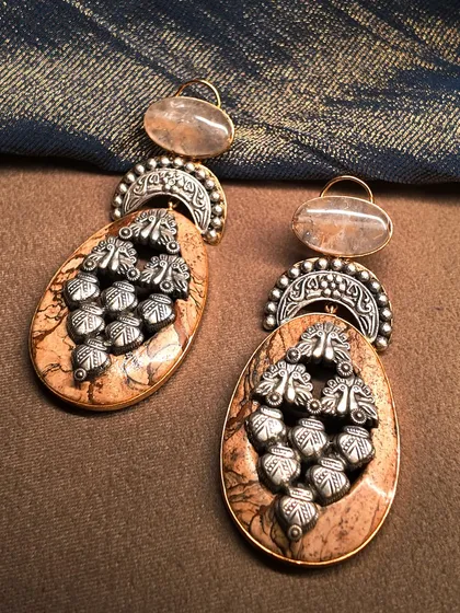 Earthy and elegant. These unique oxidized silver earrings are crafted with natural stone and intricate silverwork, perfect for a bohemian-inspired style.
