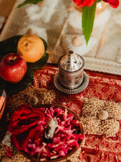 Traditional items for the wedding ceremony, including fresh fruits, flower petals, and a silver container with sacred markings. These details are essential for creating an authentic and blessed wedding experience.