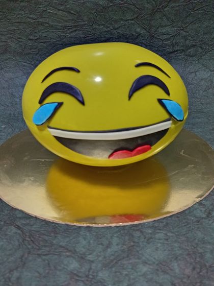 A fun emoji cake, featuring the "laughing with tears of joy" emoji. This is a playful and modern choice for any celebration.
