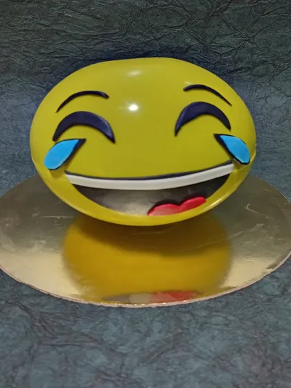 A fun and expressive emoji cake. This laughing-crying emoji is a great example of a 3D sculpted cake that brings a bit of humor to any celebration.