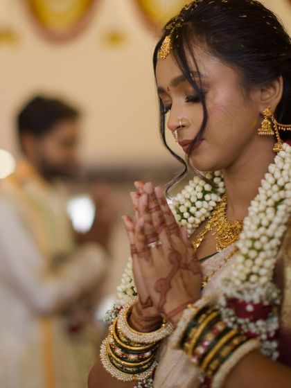The bride in a moment of quiet prayer during the ceremony, her hands joined in 'namaste'. A beautiful portrait of serenity and faith.
