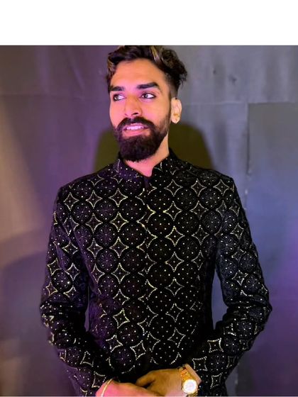 A close-up of our client looking sharp in the black embroidered sherwani. It's a versatile piece that works for a wedding, sangeet, or reception.