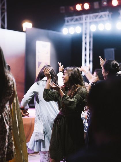 An audience member smiles as she dances, framed by the silhouettes of the crowd. I often shoot from within the crowd to give a real "point of view" feel to my photos.