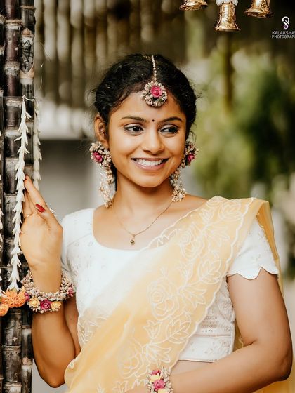 A radiant bride in her Haldi outfit, adorned with beautiful floral jewelry.