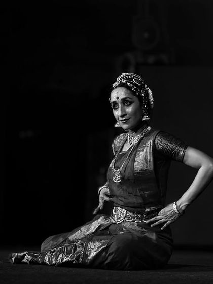 A seated pose in black and white, showing the intricate details of the costume and the focused expression.