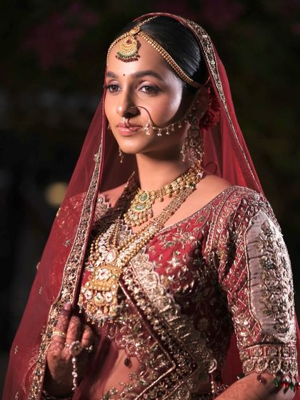 The complete regal look. Laxmi's traditional makeup, featuring defined eyes and a natural skin finish, paired beautifully with her elaborate matha patti and nath, creating a truly royal bridal profile.