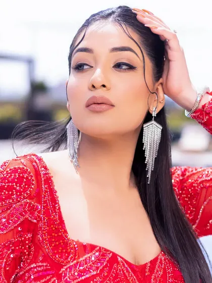 An ultra-glam makeup look with a sharp winged liner and nude lips, paired with a stunning red gown.