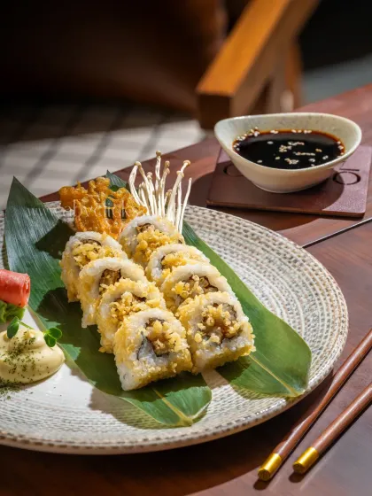 A beautifully plated sushi roll from Camo, Noida, in a natural light setting that highlights its fresh ingredients.