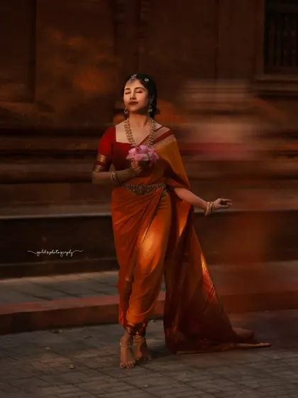A full-length version of the sunset portrait, showing the bride in a graceful pose against a warm, atmospheric background.