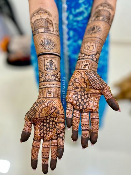 A detailed view of the engagement mehendi with Ganesha, lotus, and peacock motifs.
