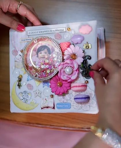 The beautifully embellished cover of the baby album, a true labor of love, being admired by the client.