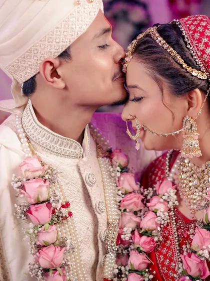 A close-up of the groom kissing his bride's forehead, capturing the love and tenderness between them.