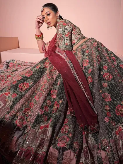 An artistic shot of the multi-color floral lehenga. The rich, dark tones and grand skirt make it a dramatic and beautiful choice for an evening function.