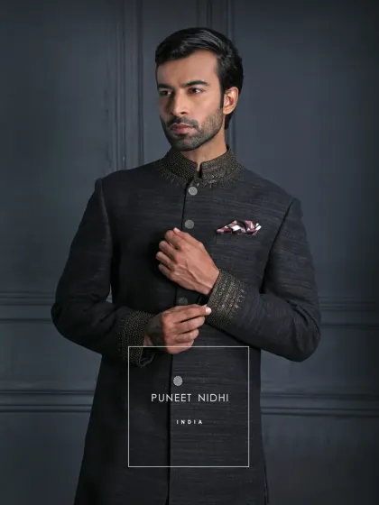 A closer look at the ash grey Matka silk Achkan, highlighting the jeweled collar and cuffs. The looped buttons trace the front with precision, a hallmark of my craft.