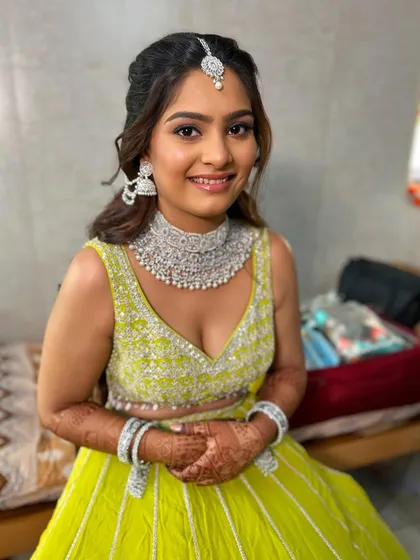 A happy and confident bride-to-be in her vibrant lime green lehenga. The makeup is fresh and modern.