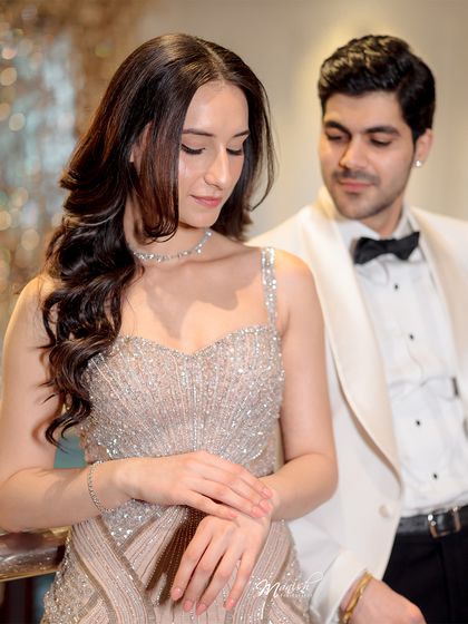A moment of quiet admiration. The groom looks on as his bride-to-be shines, a perfect capture of adoration and love.