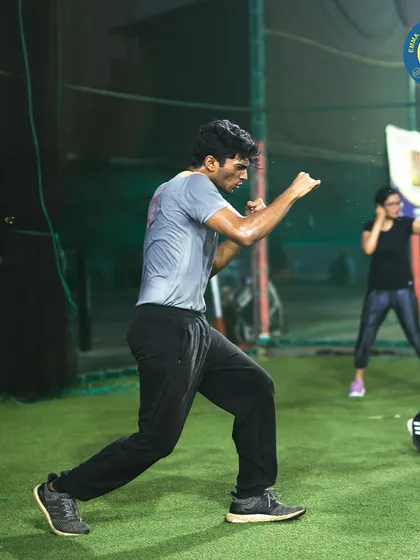 Focus and intensity during a shadow boxing warm-up. This athlete demonstrates the concentration required to perfect his movements before stepping into a more demanding workout.
