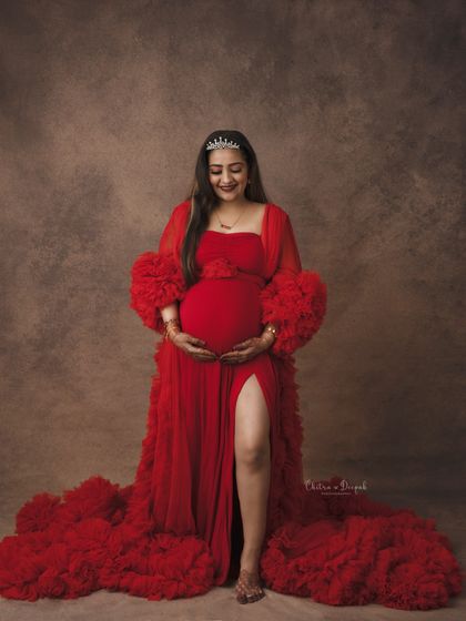 A sweet and gentle pose in a red gown. The tiara adds a touch of royalty to this beautiful and classic maternity portrait.