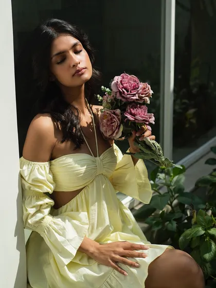 A romantic and dreamy summer portrait for It Girl, with the model holding a bouquet of flowers.