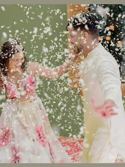 A dynamic shot of the couple playfully showering each other with flower petals during their floral-themed haldi, a moment of pure fun.