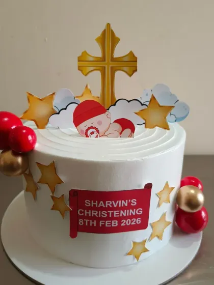 A special cake for a Christening or Baptism ceremony, decorated with a cross, stars, and a baby topper.