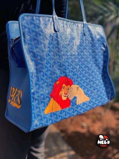 A full view of the custom Goyard tote, showing both the Lion King artwork and the personalized initials.