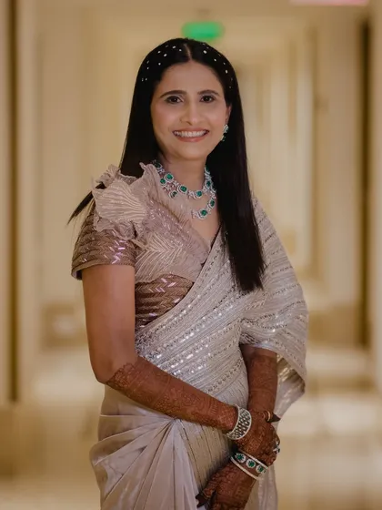A full-length view of the bride's sister. Her elegant saree and soft glam makeup create a sophisticated look.