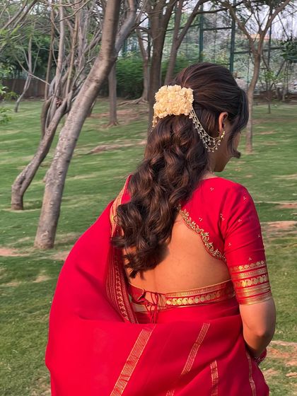 Another view of the jasmine half-updo, set against a beautiful garden backdrop.