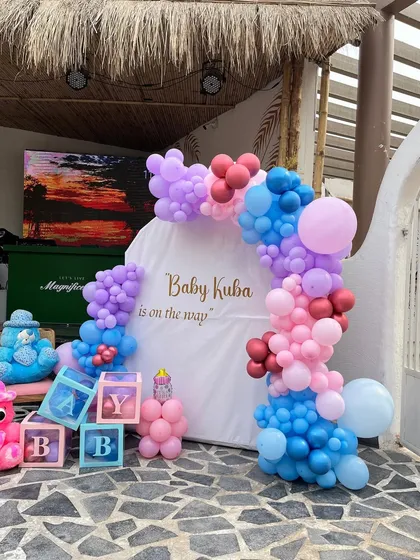 A colorful and fun baby shower setup for "Baby Kuba," featuring "BABY" blocks and a mix of pink, blue, and purple balloons.