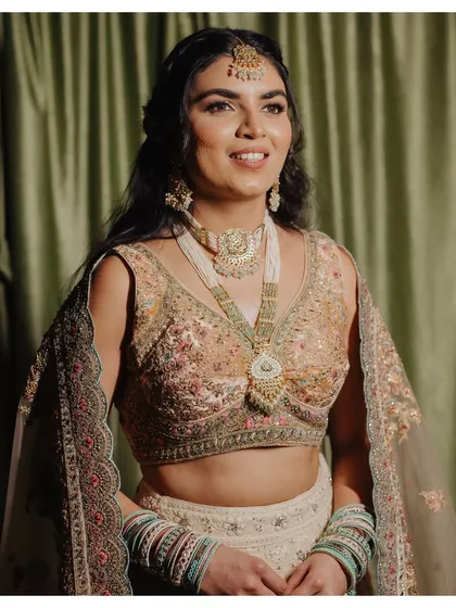 Anthiya's pre-wedding reception look was a royal charm. She was open to slightly bolder, glittery statement eyes, which we paired with a peachy flush and neutral lips.