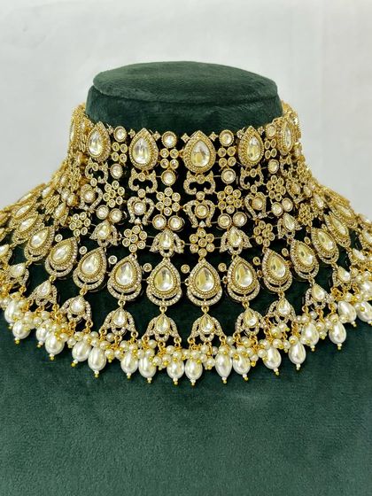 A wide bridal choker made with Kundan stones and pearl drops. This popular rental piece creates a bold and beautiful neckline.