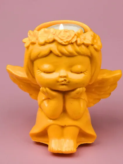 The angel figurine shown here as a tea-light holder. The warm glow of the candle brings out the peaceful details of the handcrafted Jesmonite piece.