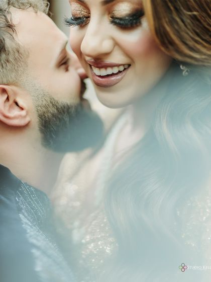 An extreme close-up capturing the bride's joyful smile and the groom whispering in her ear, a candid moment full of love and happiness.