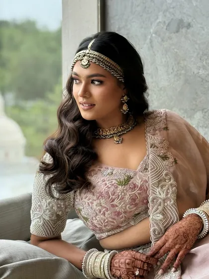 A soft and romantic open hairstyle for a daytime wedding. The gentle waves are complemented by a traditional matha patti, creating a look that is both modern and timeless.