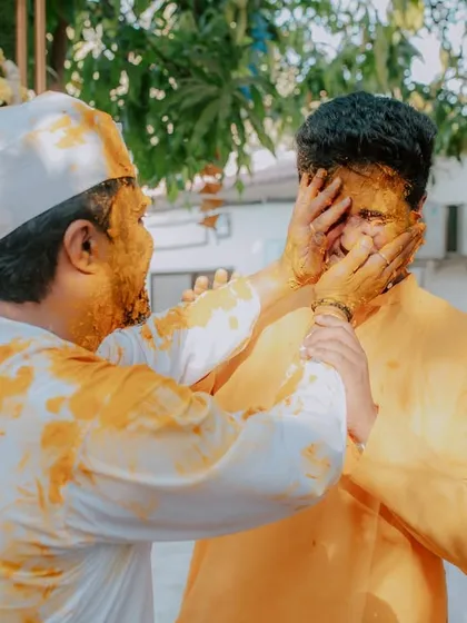 A candid moment of fun between the groom and his friend or brother during the Haldi ceremony. It's these unposed interactions that show the true spirit of the day.