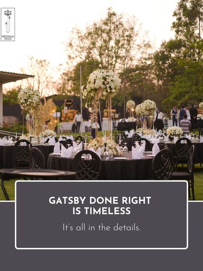 A Gatsby theme done right is timeless. This wide shot shows the complete event setup, where every detail, from the tall centerpieces to the black linens, works together to create a sophisticated and immersive experience.