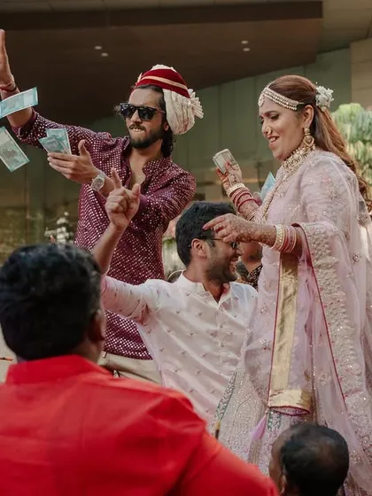 Making it rain! The bride's family joins the Baraat fun, showering the procession with love and currency notes in a traditional gesture of celebration.