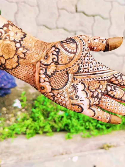 A lovely, full-palm design that is perfect for a family member at a wedding. It's intricate and dense, with a beautiful floral wristband.