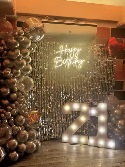 The full view of the chic 21st birthday decoration, showing the complete balloon garland and lighting.