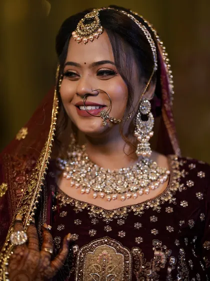 A happy bride in a deep velvet lehenga. Her smile and glowing makeup make for a perfect reception look.