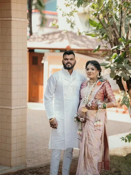 A full-length photo of the couple at their baby shower. Her floral jewellery set was designed to complement her traditional saree.