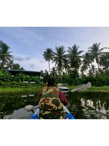 Paddling back towards the camp, with the lush greenery and palm trees of our property in view.
