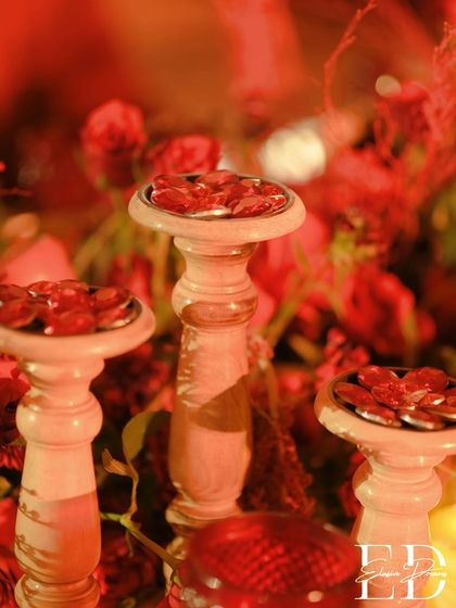 A close-up of decorative red gems on wooden pedestals, adding a touch of sparkle to the table decor.