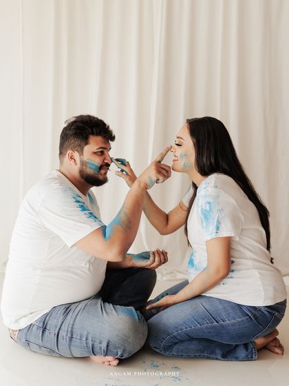 Let's have some fun. This playful moment from a gender reveal shoot, with blue powder, captures the excitement and joy of finding out who you'll be meeting soon.