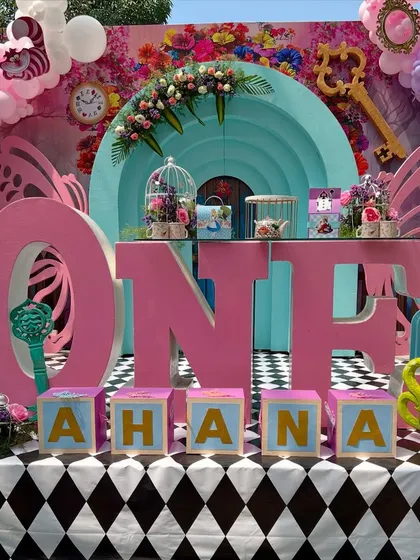 Ahana's 'Onederland' party was a journey down the rabbit hole. The main table setup featured giant 'ONE' letters, a checkerboard floor, and tons of custom props like the grinning Cheshire Cat and a giant teacup, bringing the storybook to life.