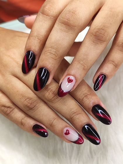 A still image of the red and black Valentine's nails, highlighting the contrast between the sharp cat-eye design and the soft heart details.
