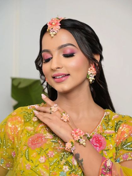 A close-up showing the details of the floral jewelry and the beautiful pink eyeshadow. This look is perfect for a bride who wants to have fun with her makeup.