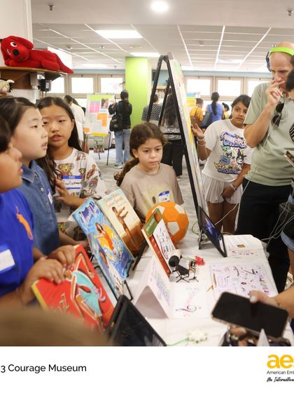 Students, parents, and teachers engage with the interactive displays at the Courage Museum. The event was a culmination of a unit where third graders explored the theme of courage through personal interviews and biographical research.