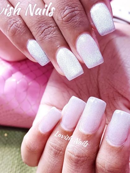 A set of square nails with a shimmery, pearlescent white finish.